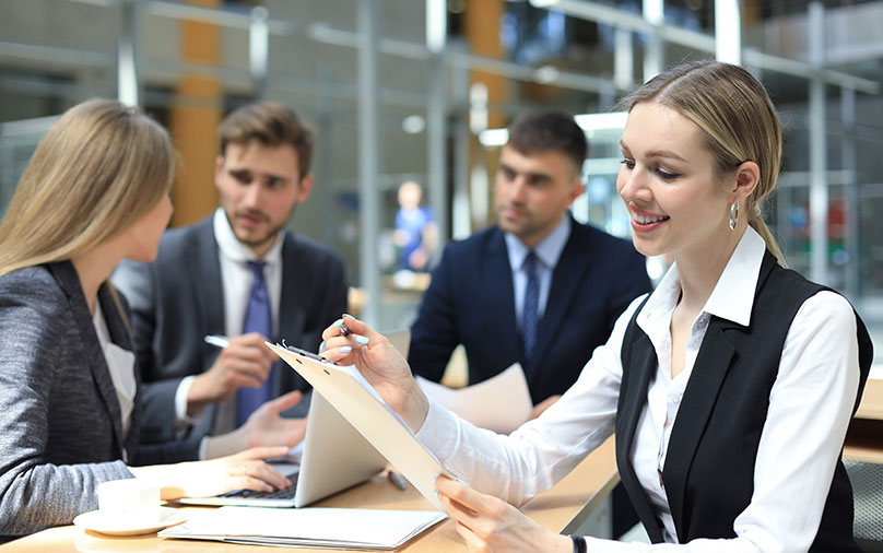 Business woman with her staff, people group in background