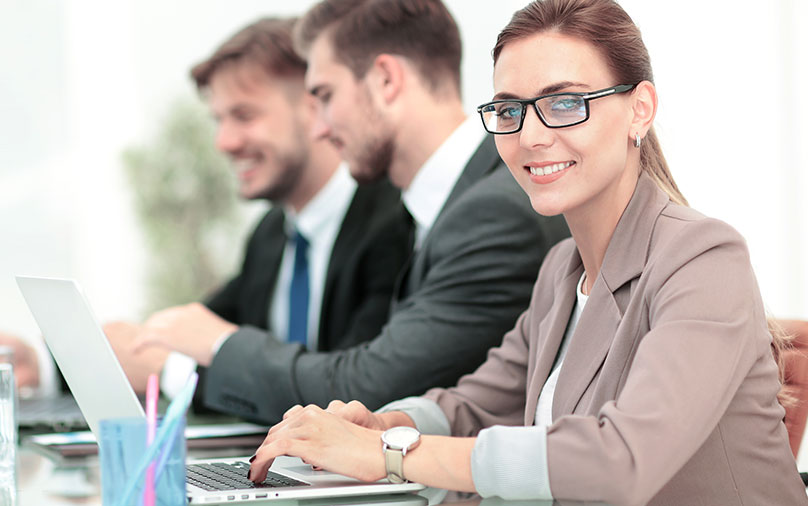 Portrait of happy business woman with colleagues